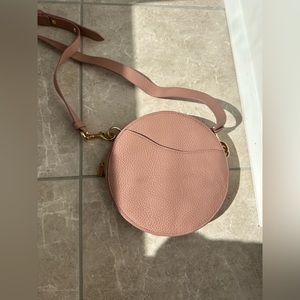 Round beltbag in neutral mauve color by Cuyana
